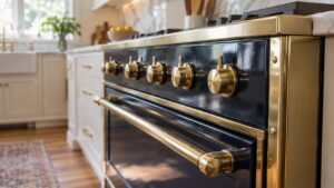 A close-up of the glossy enameled front panel of a French range with brass trim running along its edge