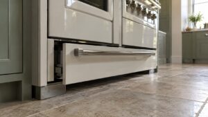 The base of a luxury range showing a warming drawer slightly open and misaligned, not sitting flush with the surrounding enamel panel